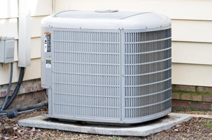 An outdoor heat pump unit sitting on a concrete slab outside of a white paneled home.